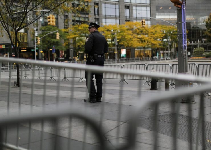 [Photo: A police officer stands guard in New York City]