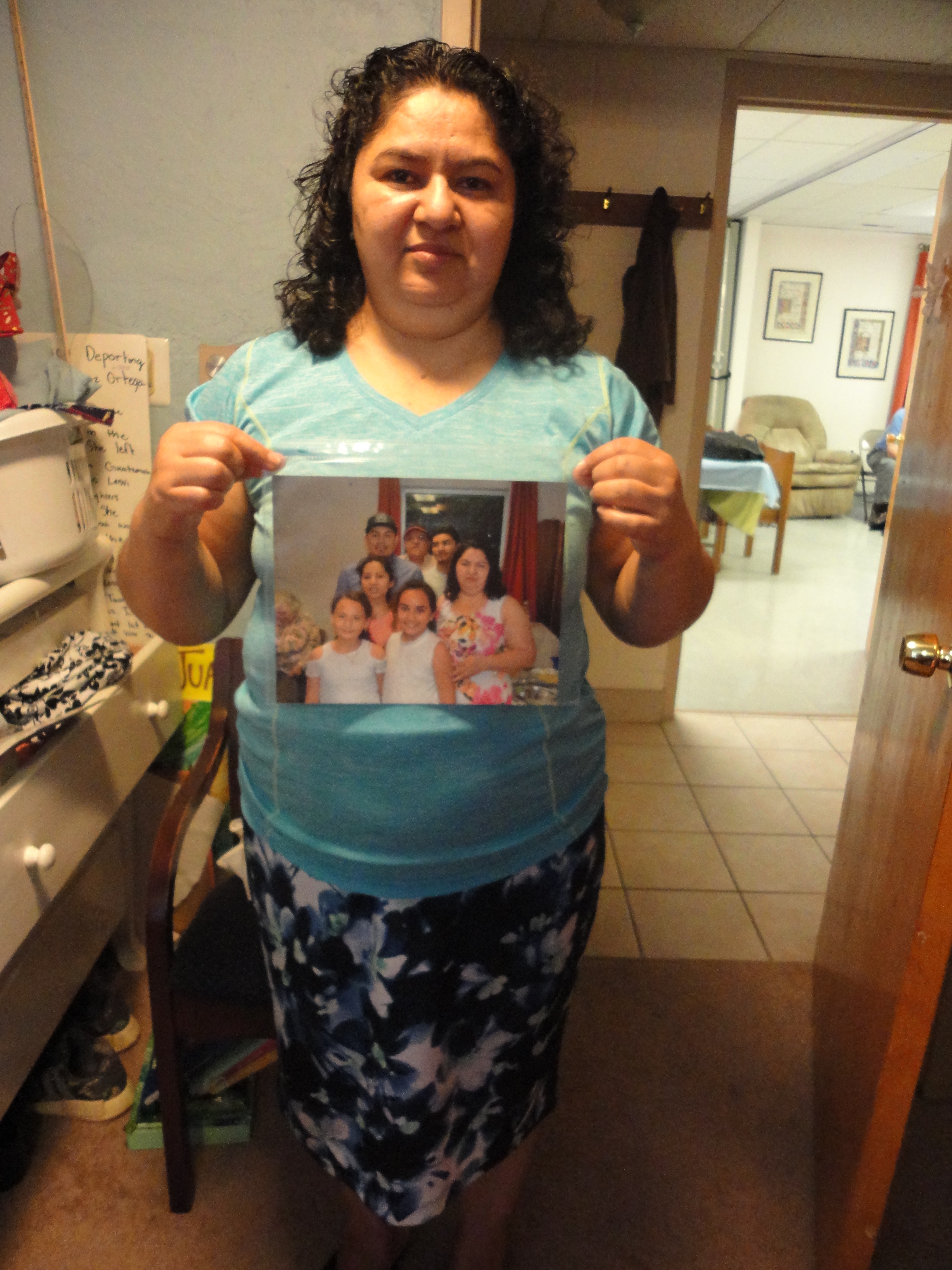 [Photo: Juana Luz Tobar Ortega holds a picture of her family]