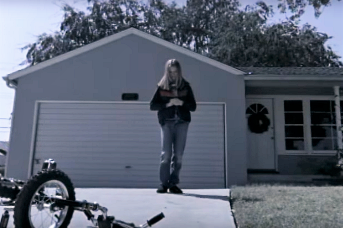 [Photo: A teenage girl stands near a garage in the Ben Folds Five's music video "Brick"]